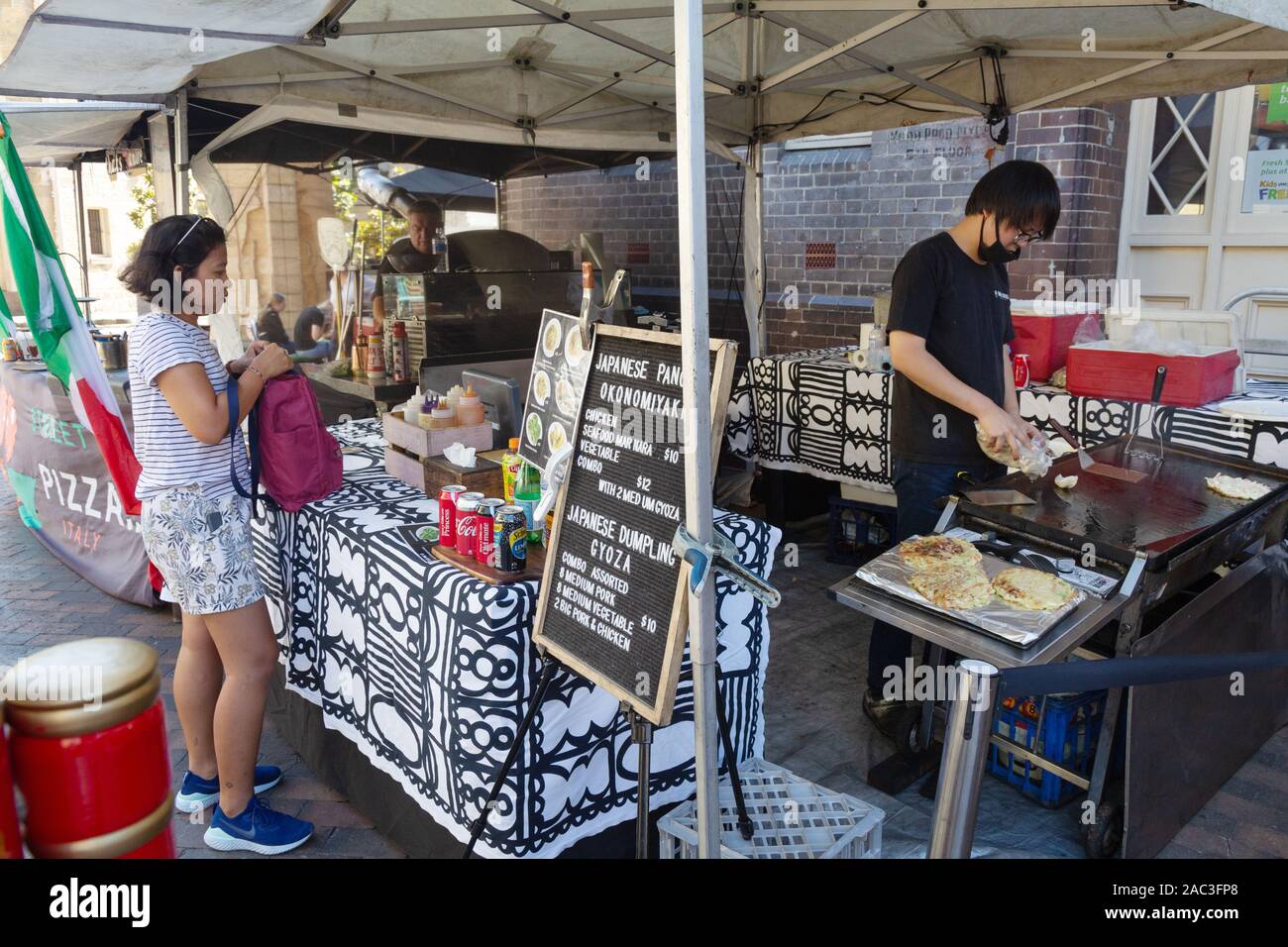 The Rocks market Sydney Australia - a woman buying street food at a market stall at the weekend market in The Rocks area of Sydney, Australia Stock Photo