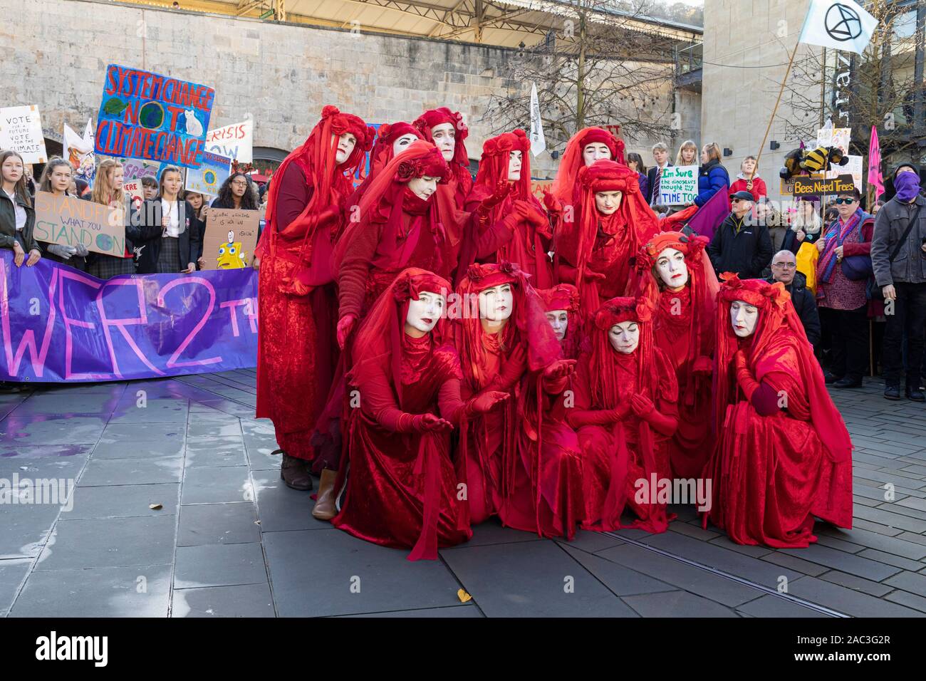 Extinction Rebellion Red Brigade climate change protesters march through Bath City centre with Bath Youth Climate Alliance campaigning for action. UK Stock Photo