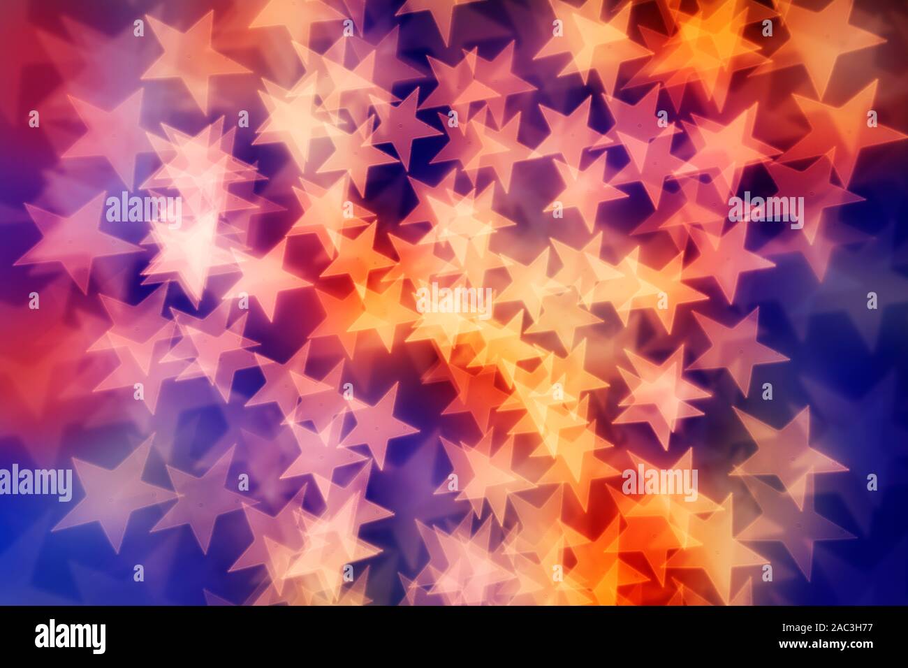 Star shaped bokeh background in yellow, reds and purple tones. Stock Photo