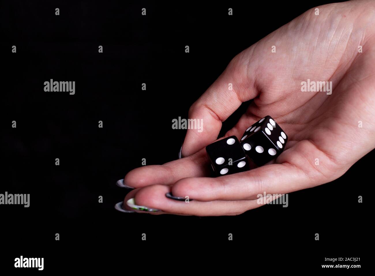 dices in the female hand with black background Stock Photo