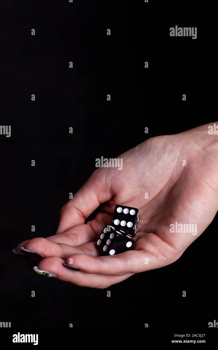 dices in the female hand with black background Stock Photo