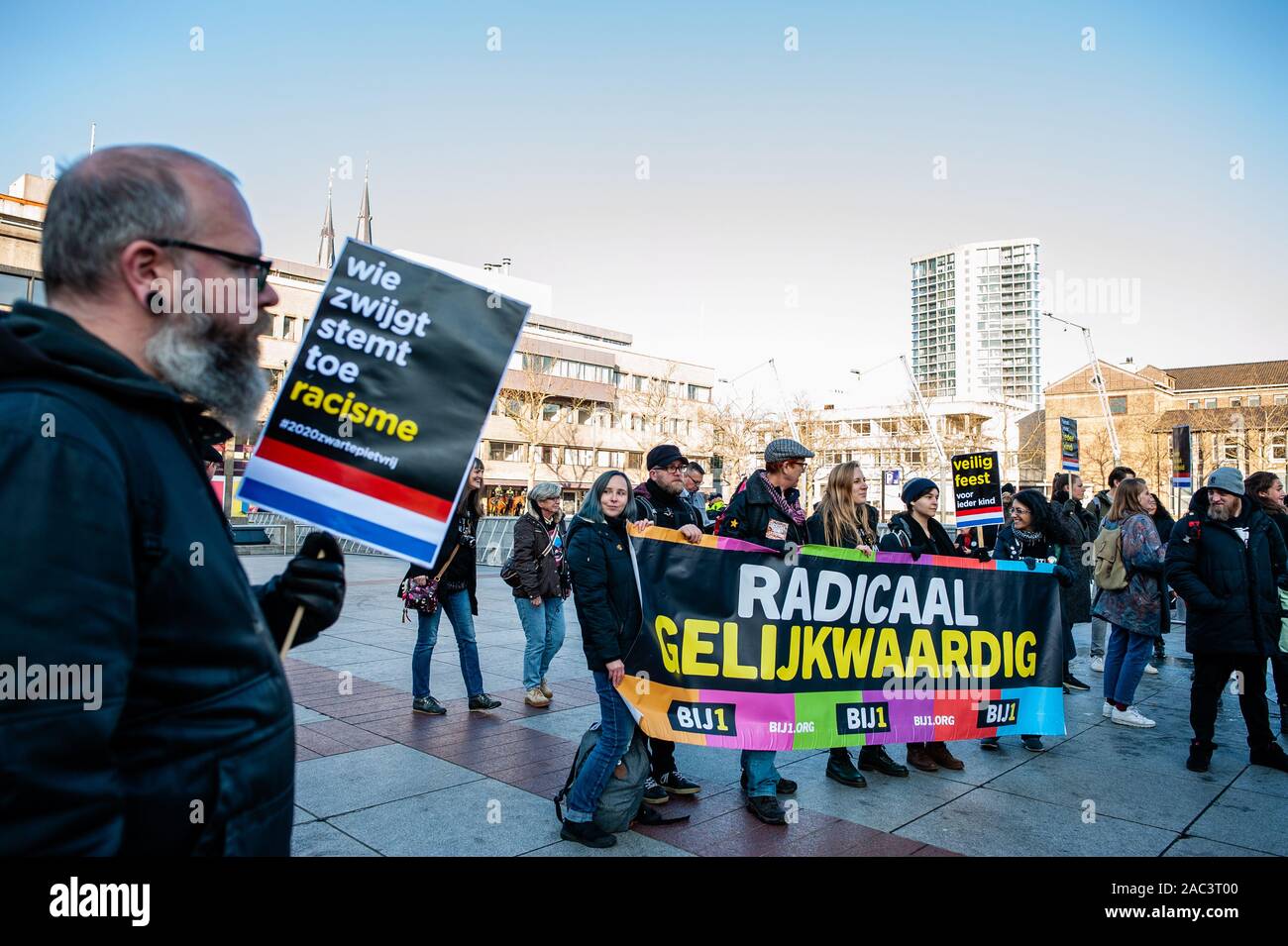 A protester holds a placard during the rally.The Anti-Zwarte Piet group Kick out Zwarte Piet (KOZP) organized a rally against Sinterklaas’ black-faced helpers, in Eindhoven. The group feels that the traditional form of Zwarte Piet (Black Piet) is a racist caricature. Also, during the last weeks, some of them have suffered verbal and physical racist attacks. In Eindhoven, around fifty people gathered to speak out against racism and violence from radicalized pro-Zwarte Piet groups. Stock Photo