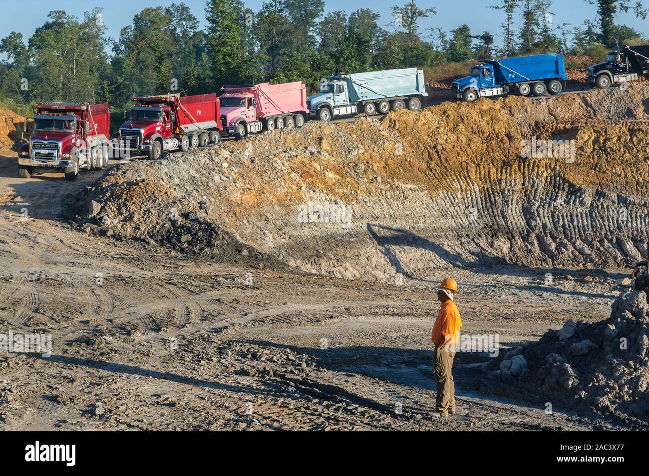 The owner of KR Trucking, watches as his fleet of Mack Granite dump trucks head into a clay pit, Sept. 20, 2016, in Huntingdon, Tennessee. Stock Photo