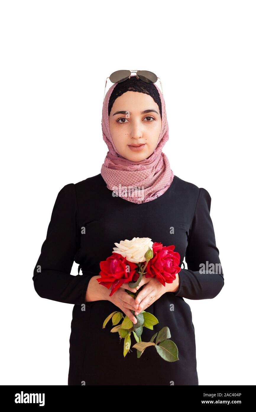 Stylish Muslim woman in traditional Islamic clothing holding flower