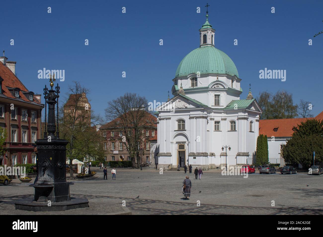 Church of the Sisters of the Holy Sacrament dedicated to St. Kazimierz and historic well, New Town Square, Warsaw, Poland Stock Photo