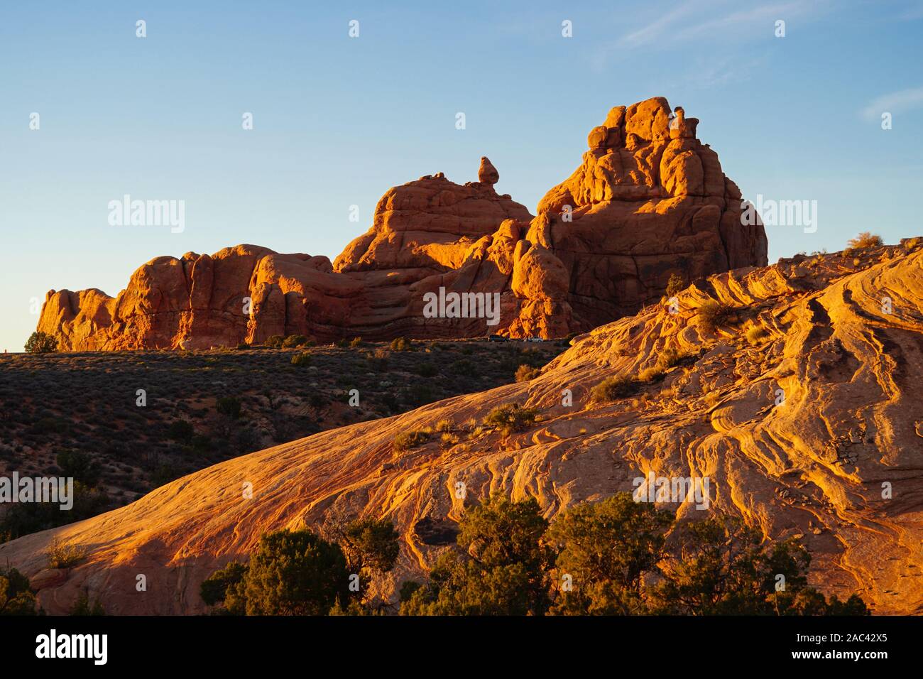 The brilliant reds and oranges of the sandstone formations in Arches National Park at sunset. Stock Photo