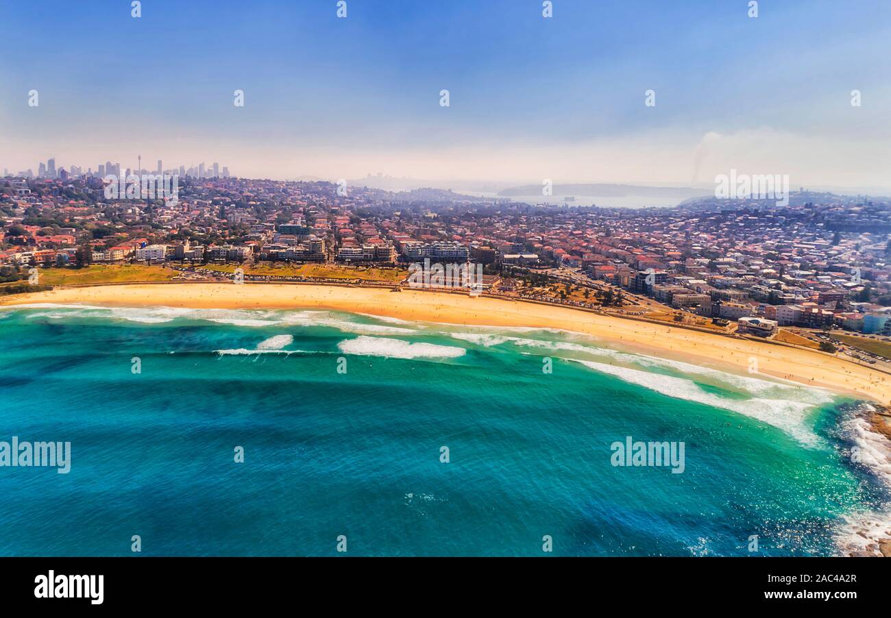 Thick haze in air over Greater Sydney due to bushfires - elevated aerial view from Pacific ocean towards Bondi beach and distant city CBD and Harbour Stock Photo