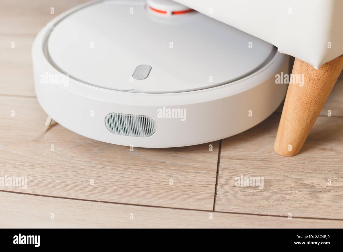 Robot vacuum cleaner vacuuming under the bed Stock Photo Alamy