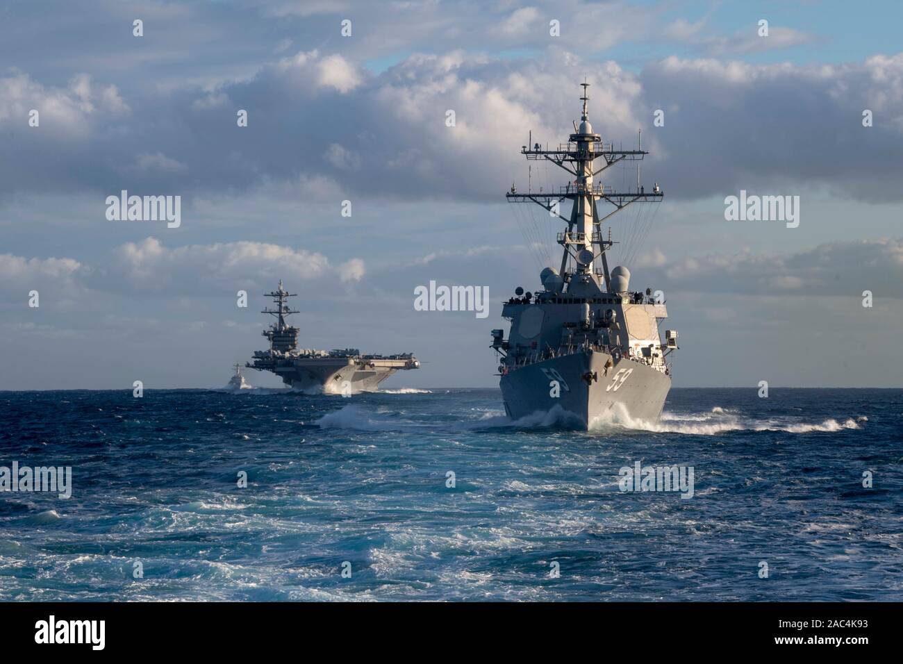 PACIFIC OCEAN (Nov. 27, 2019) The Arleigh Burke-class guided-missile destroyer USS Russel (DDG 59) and the aircraft carrier USS Theodore Roosevelt (CVN 71) transit the Eastern Pacific Ocean Nov. 27, 2019. Paul Hamilton is underway conducting routine training in the Eastern Pacific Ocean. (U.S. Navy photo by Mass Communication Specialist 3rd Class Matthew F. Jackson) Stock Photo