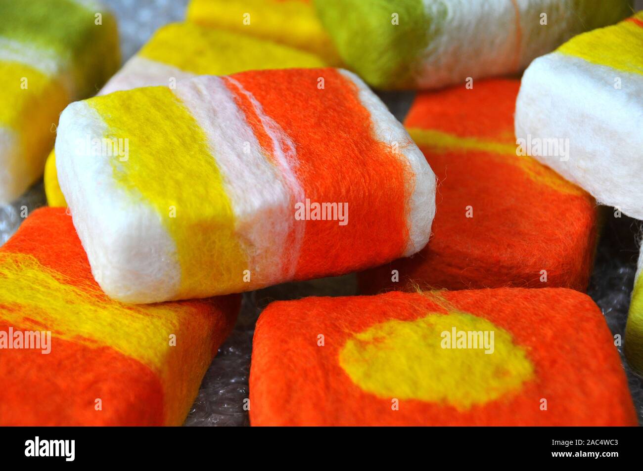 Bars of soap being covered with felt in a wet felting process Stock Photo
