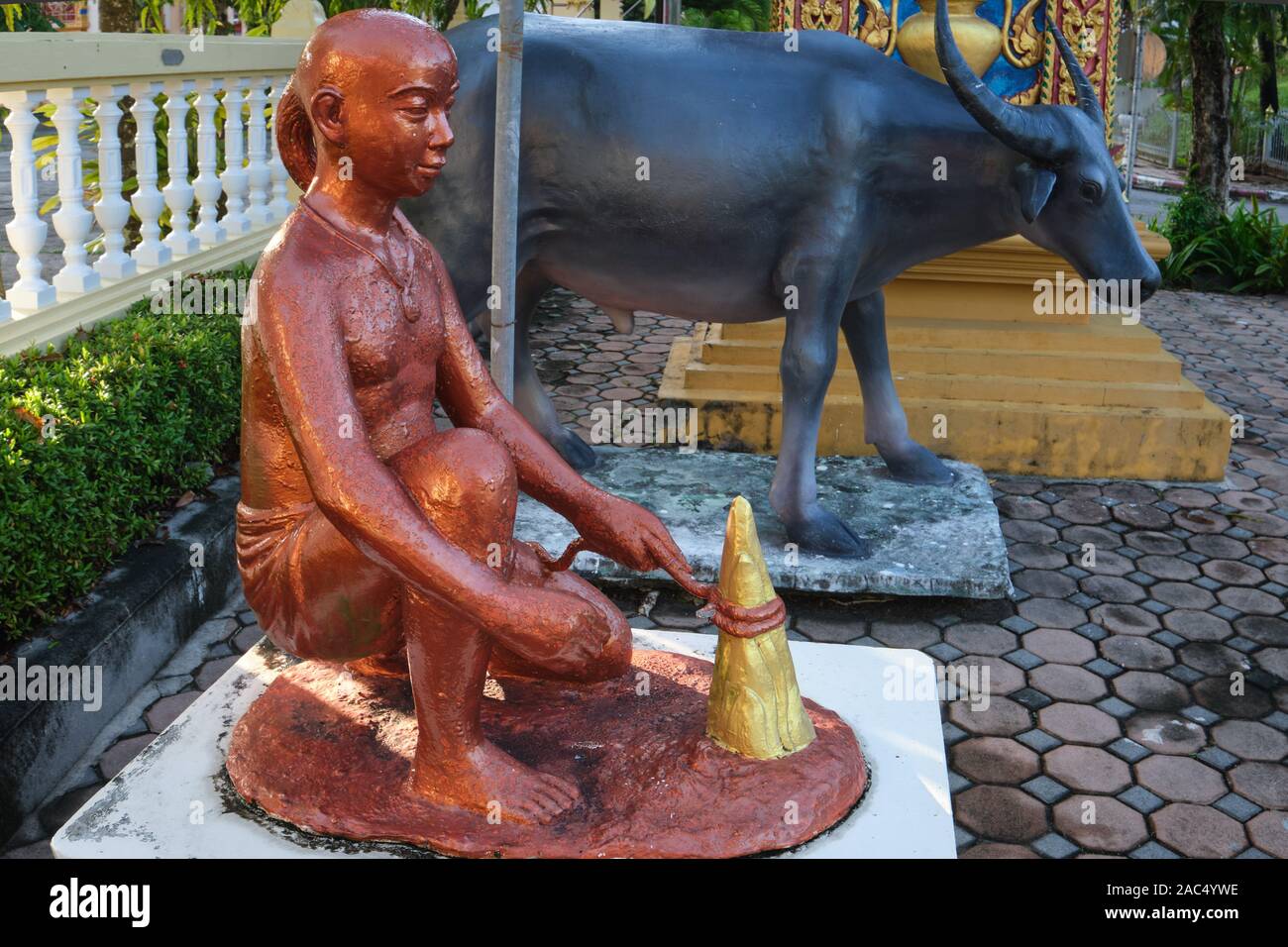 Statues at Wat Phra Thong, Thalang, Phuket, Thailand, depicting the legend surrounding the temple, a cowherd finding the temple's buried Buddha statue Stock Photo