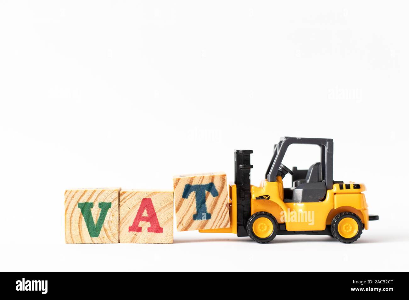 Toy forklift hold wood letter block T to complete word VAT