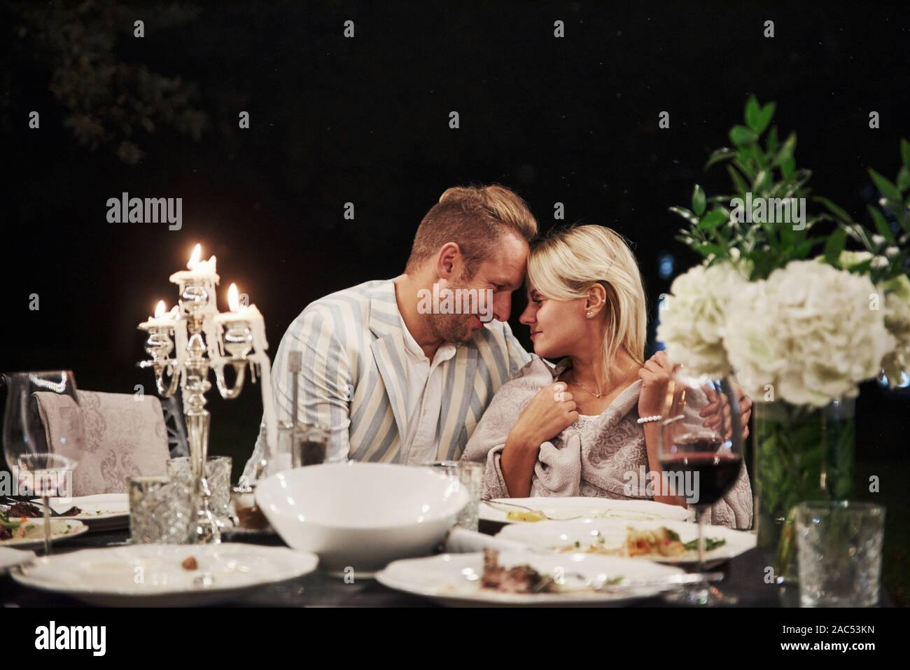Looking at each other with love. Beautiful adult couple have a luxury dinner at evening time Stock Photo