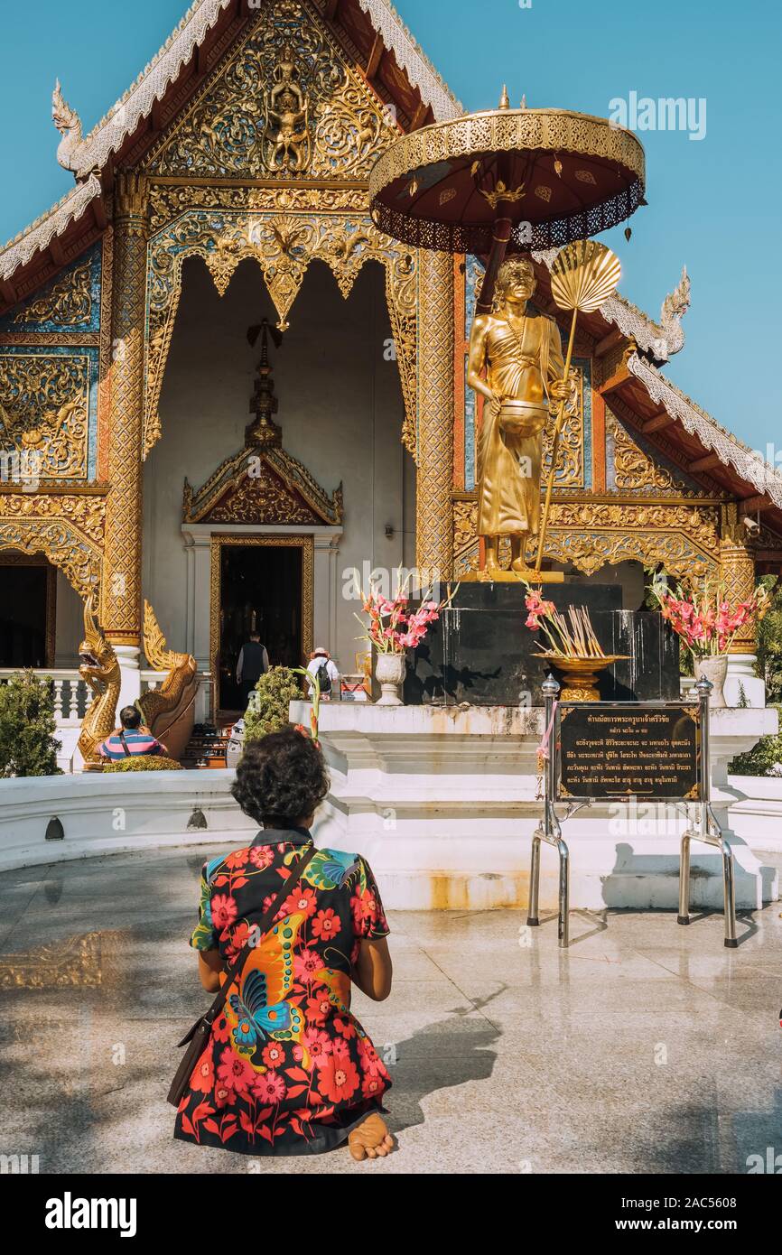 Unidentified thai woman praying in front of Wat Phra Singh temple in Chiang Mai, Thailand.  Stock Photo