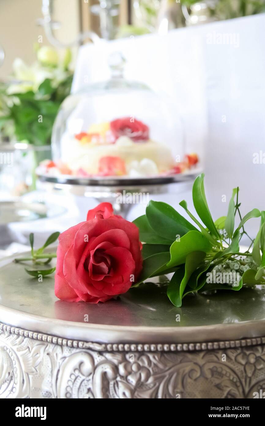 Red Rose Laying On A Decorative Silver Cake Display Board For