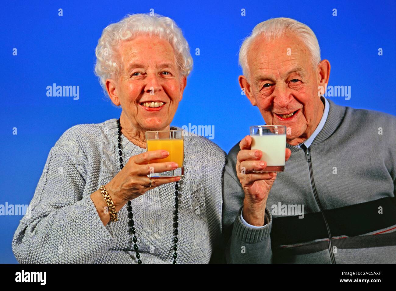 Senioren-Ehepaar trinkt Milch und Orangensaft Stock Photo