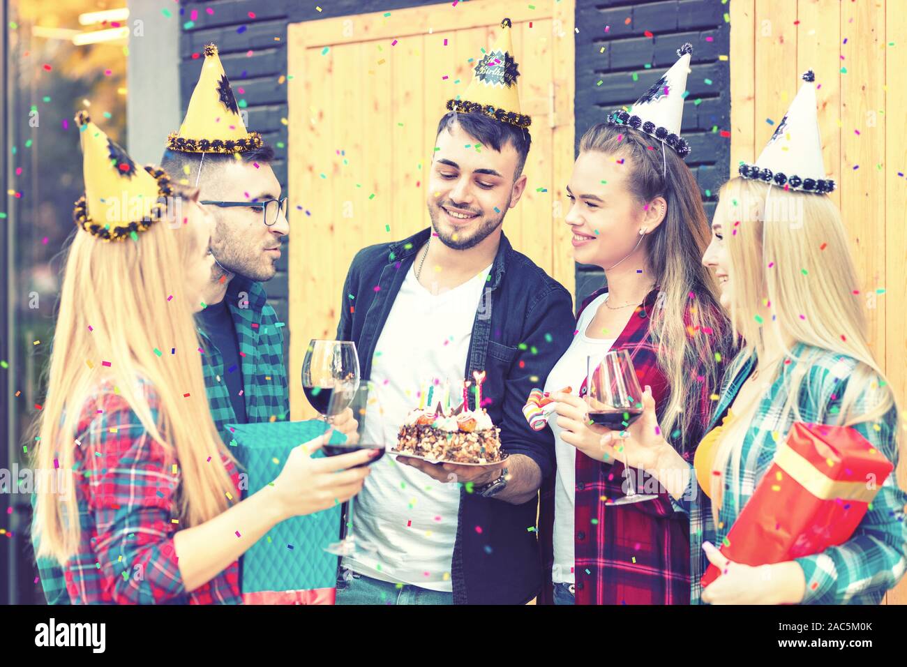 Birthday party with young millennial friends celebrating at home backyard terrace Stock Photo