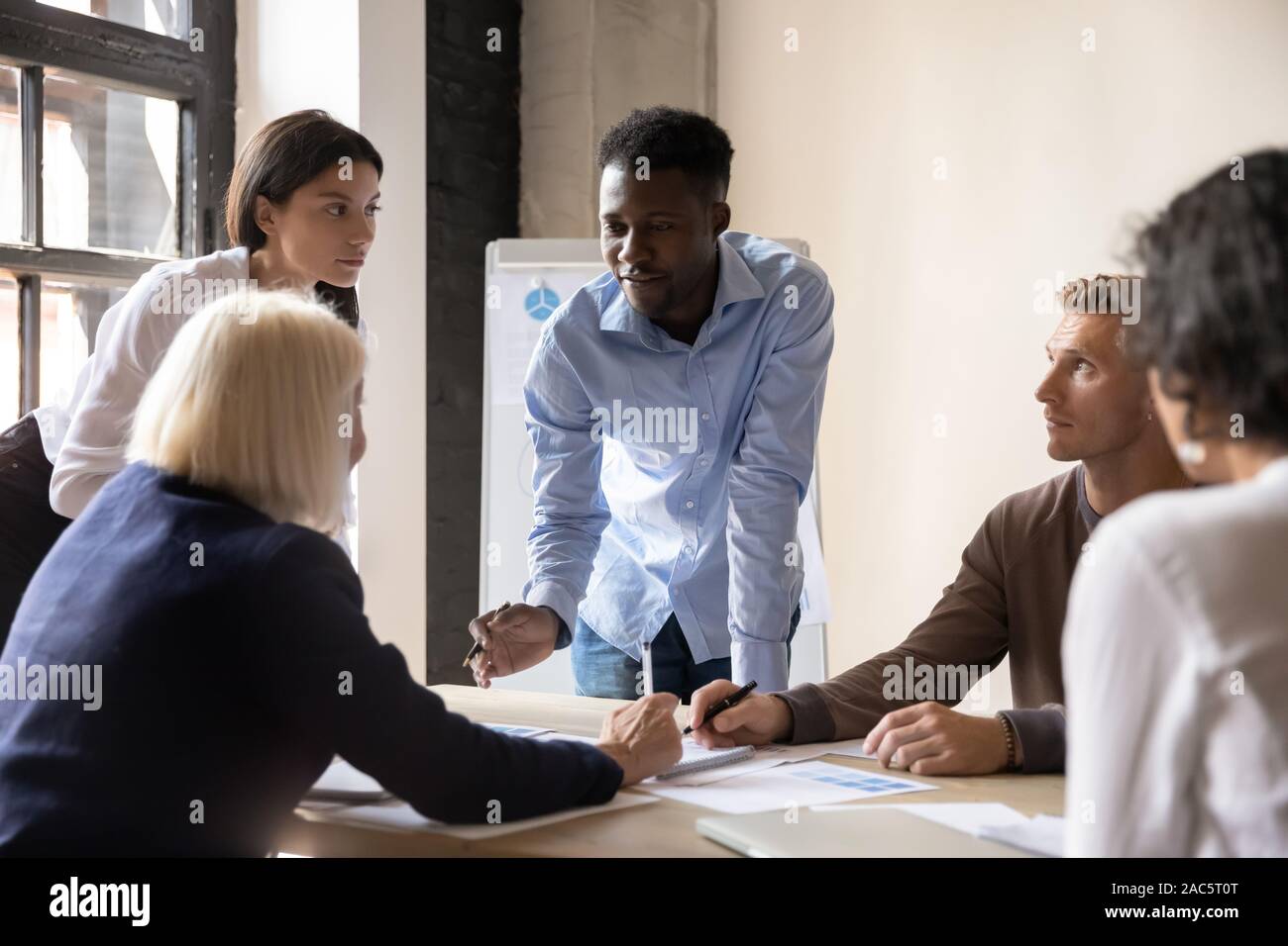 Focused diverse coworkers developing marketing strategy at office. Stock Photo