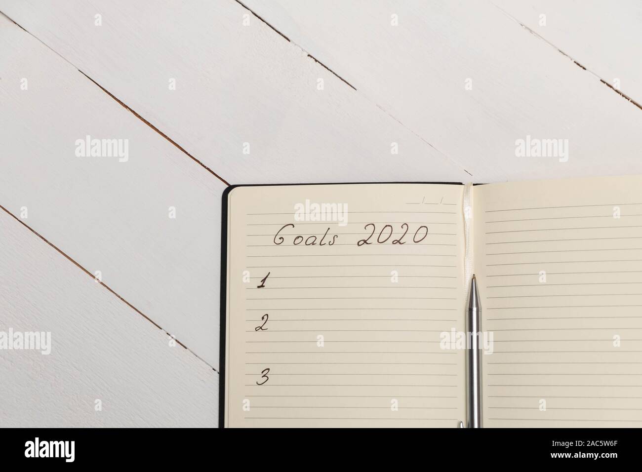 Top view composition with journal with handwritten words "Goals 2020" Stock Photo