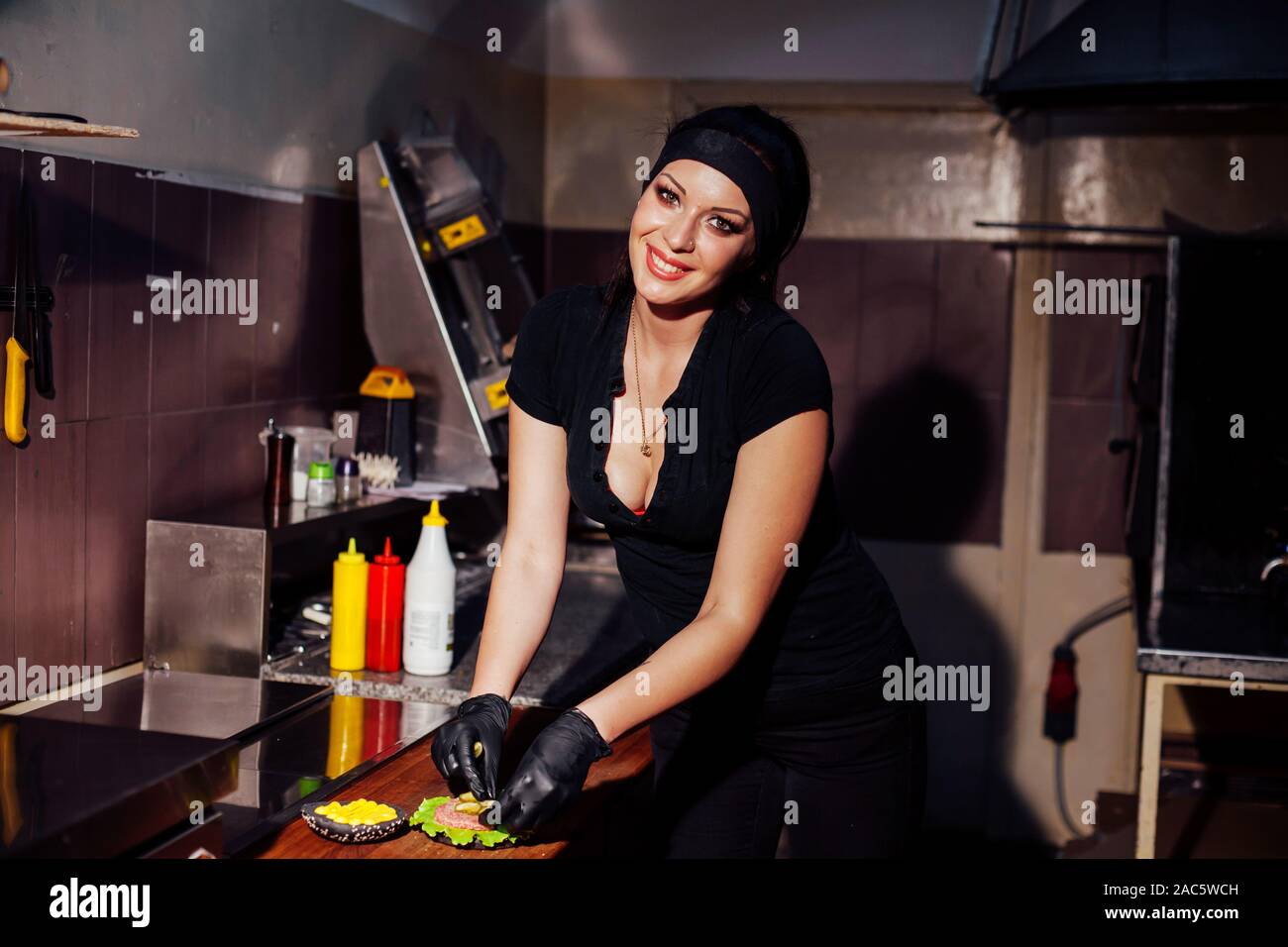beautiful girl Cook prepares the kitchen Burger Stock Photo