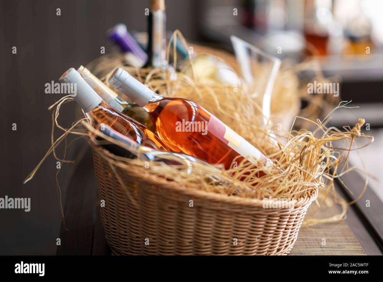 scrumptious wine bottles standing horizontally in a picnic basket. Stock Photo