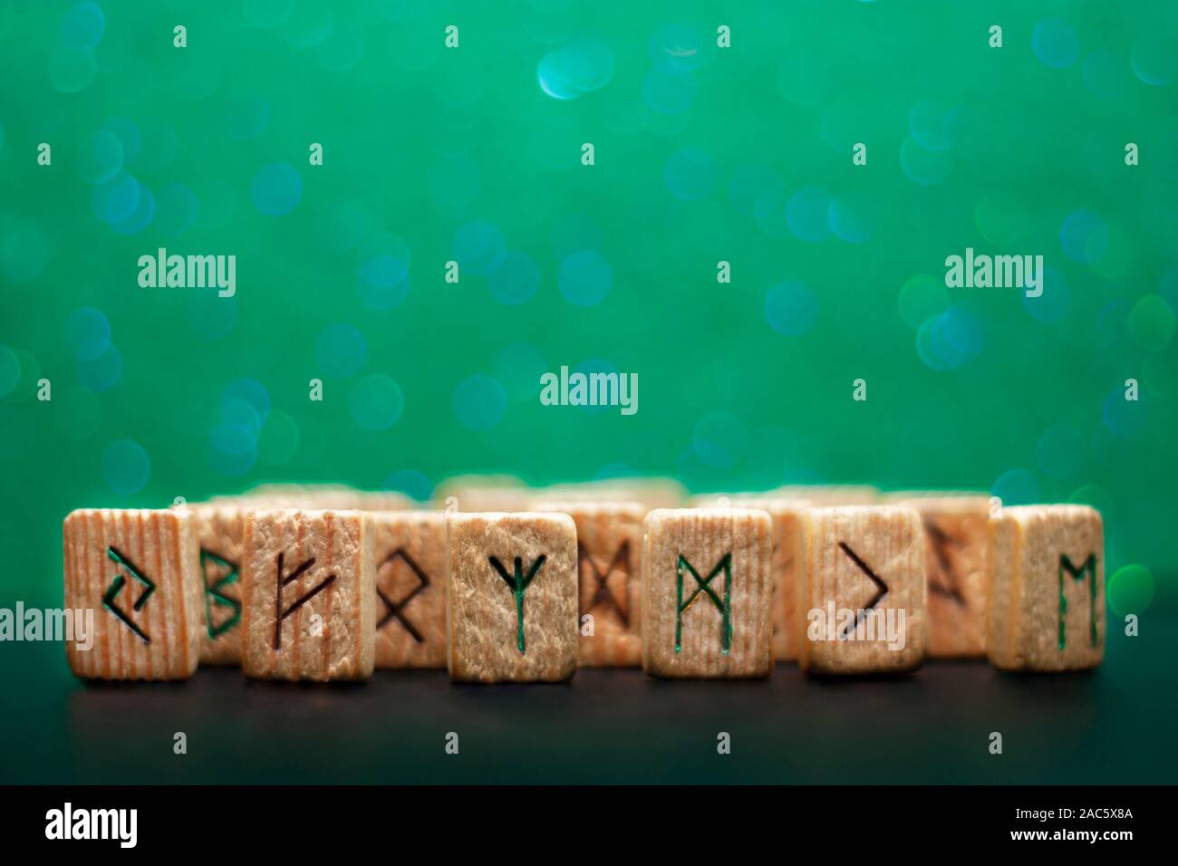 Group of old wooden runes on a green bokeh background Stock Photo