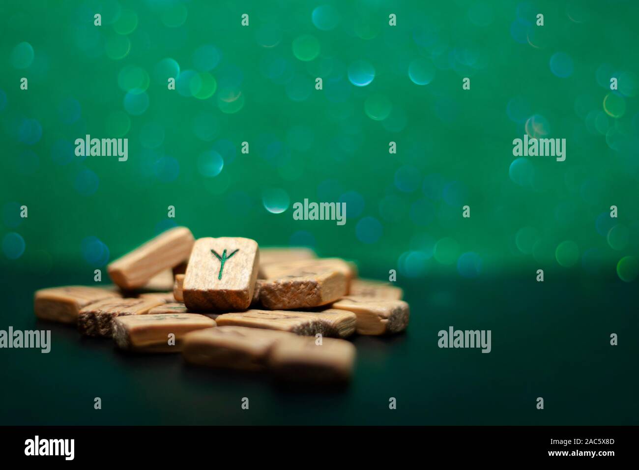 Group of old wooden runes on a green bokeh background Stock Photo