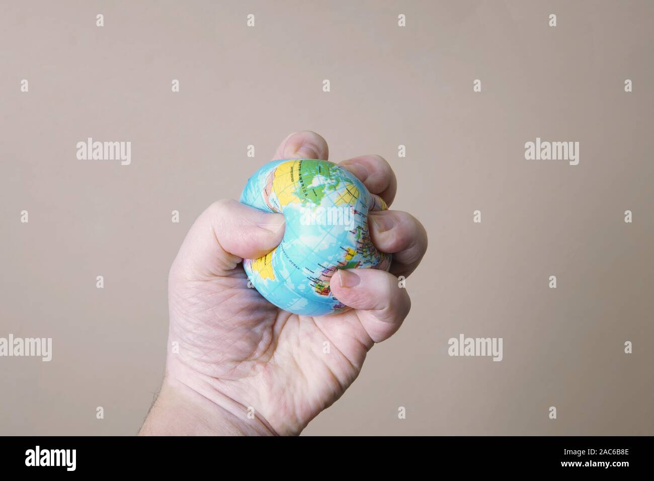 ecocide concept - hand crushing or squashing globe of planet earth - destruction of the environment Stock Photo