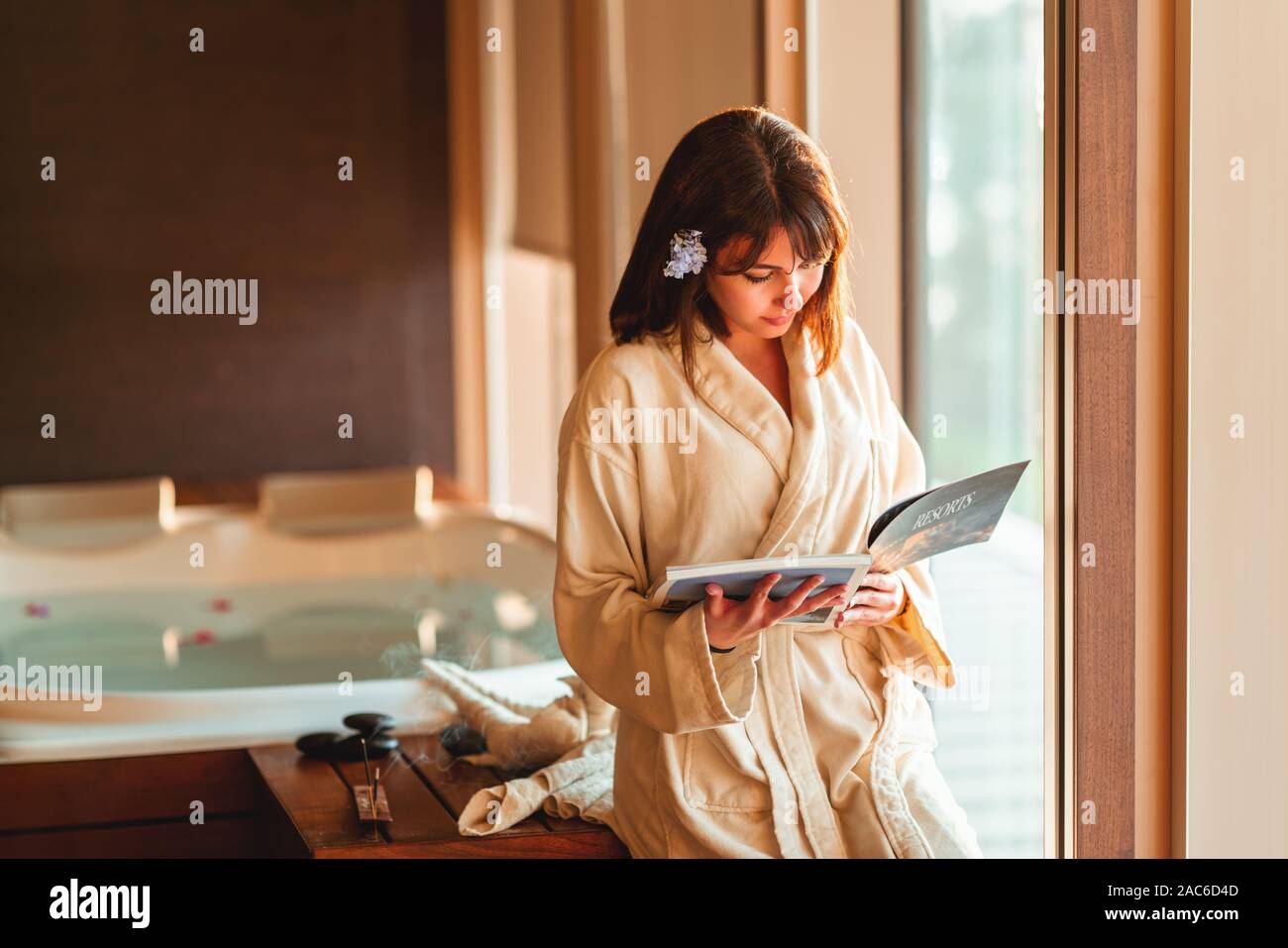 woman reading magazine while waiting at spa center Stock Photo