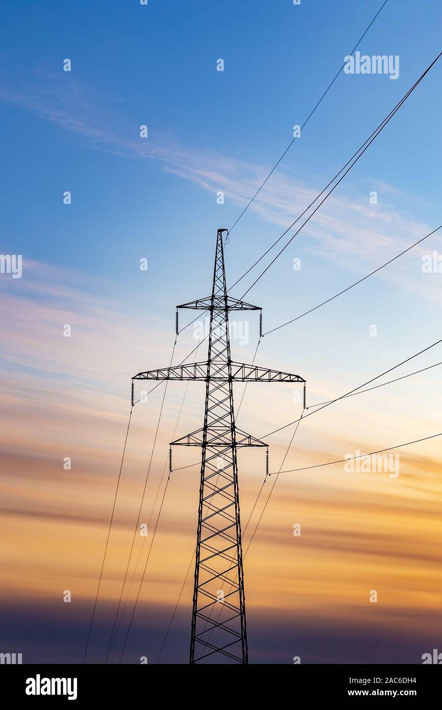 Silhouette of electricity pylon at sunset sky background Stock Photo ...