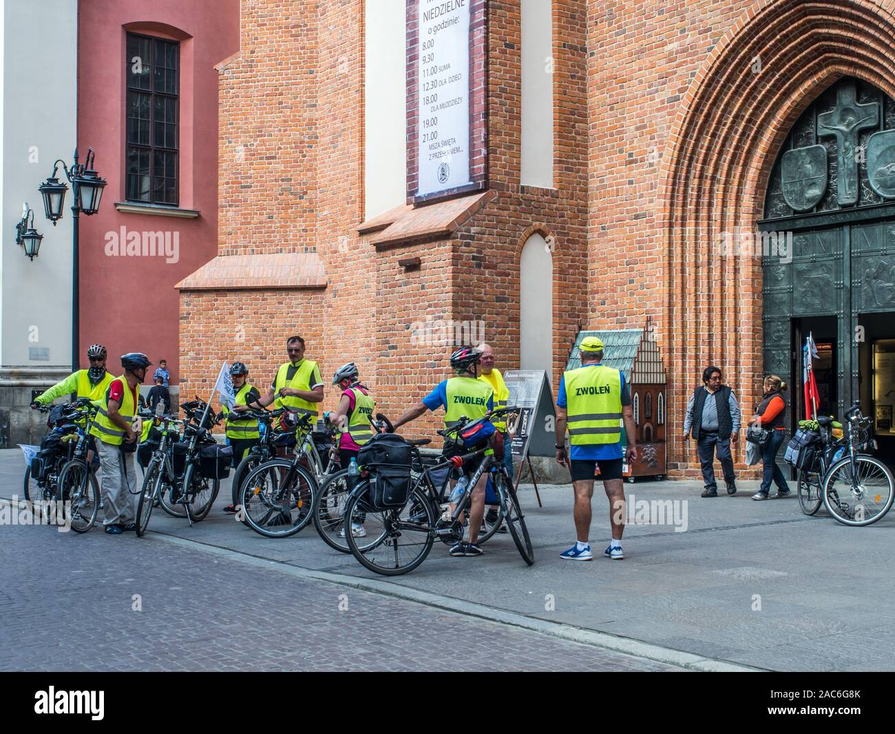 Warsaw, Poland - June 02, 2017: Cyclists in yellow vests at Old Town Square (Rynek Stare Miasto) during the summer time, UNESCO World Heritage Site. Stock Photo