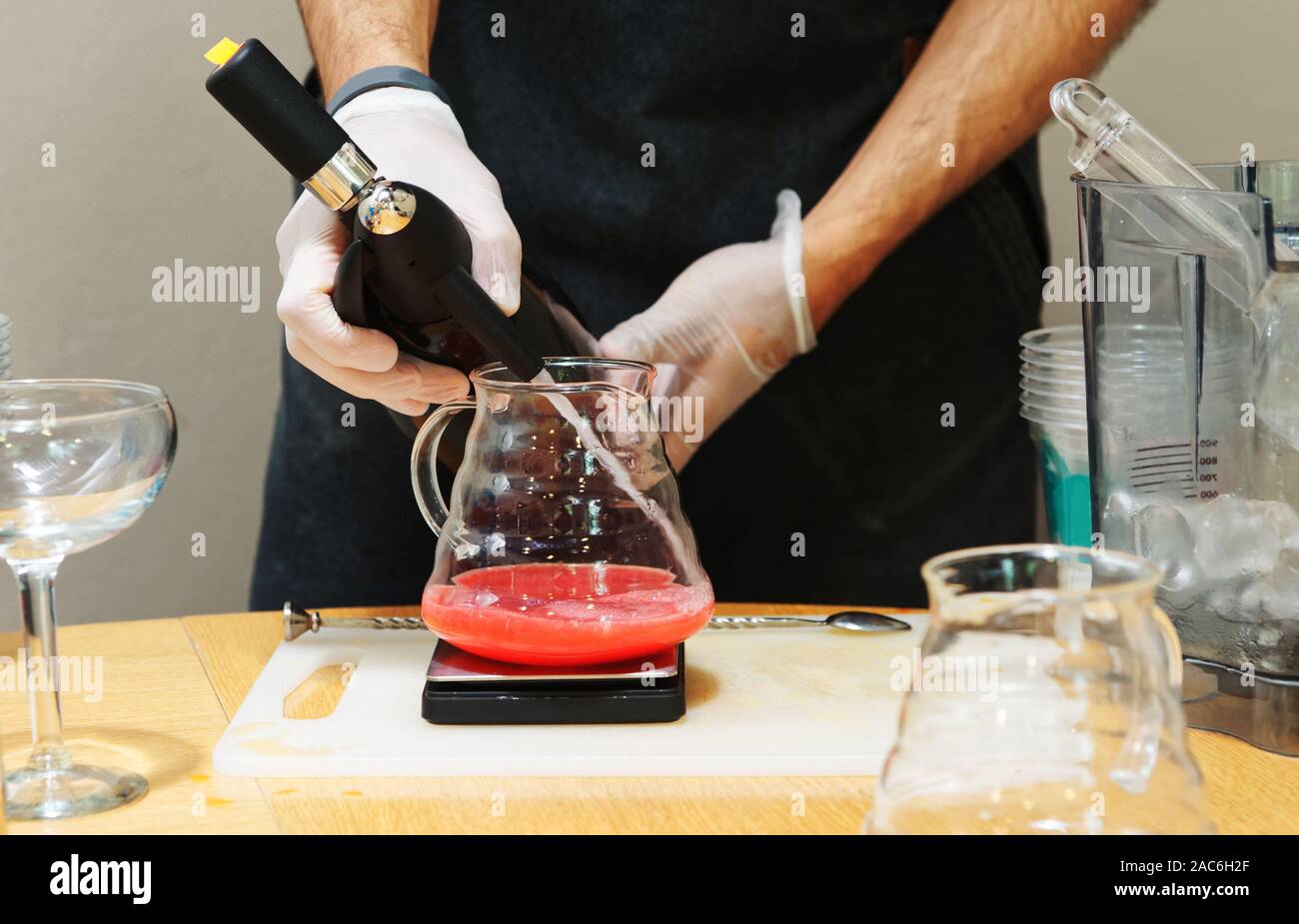 Bartender is adding soda water to a berry drink, toned image Stock Photo Alamy