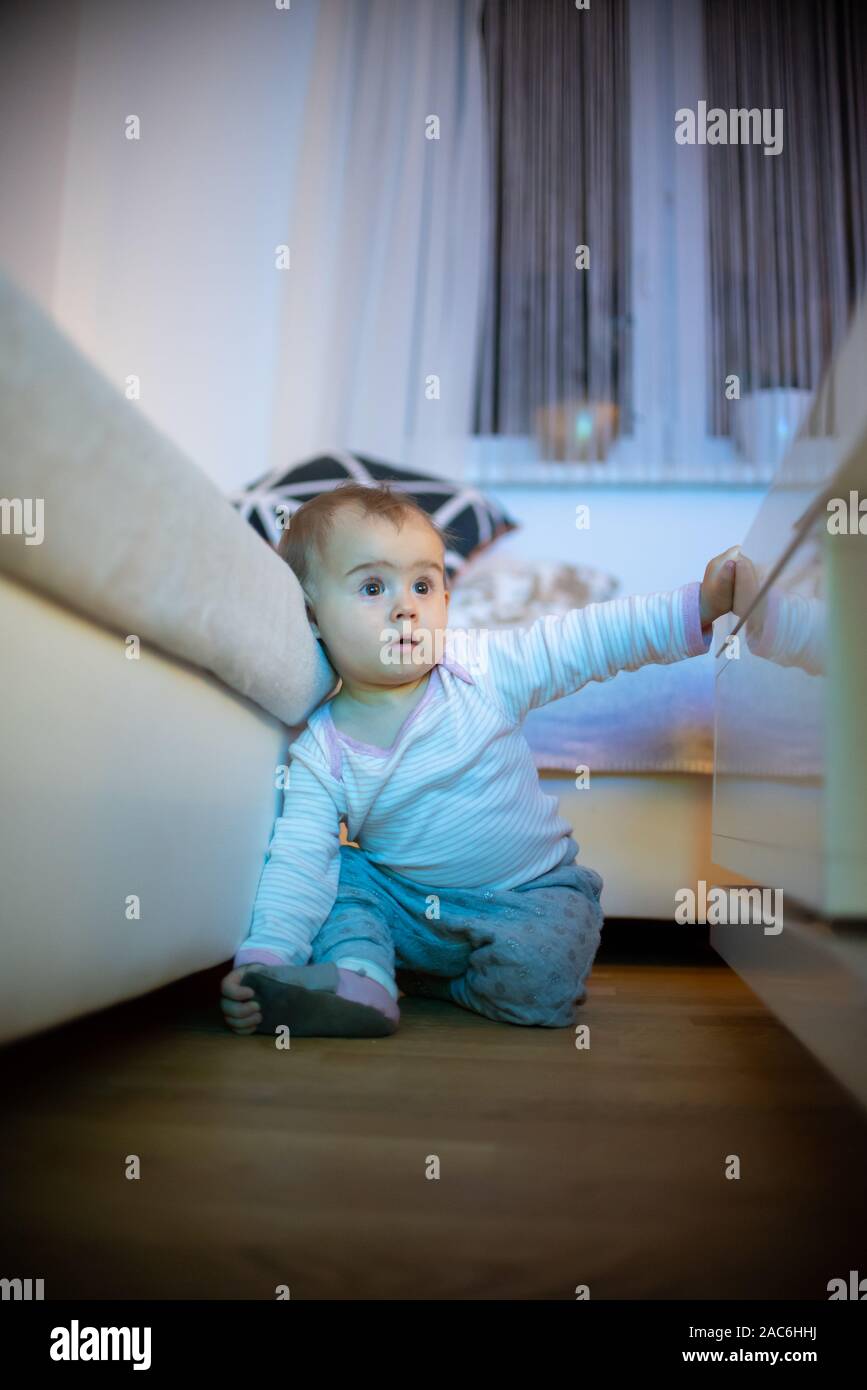 11 months old baby girl watching television like hypnotized. health and