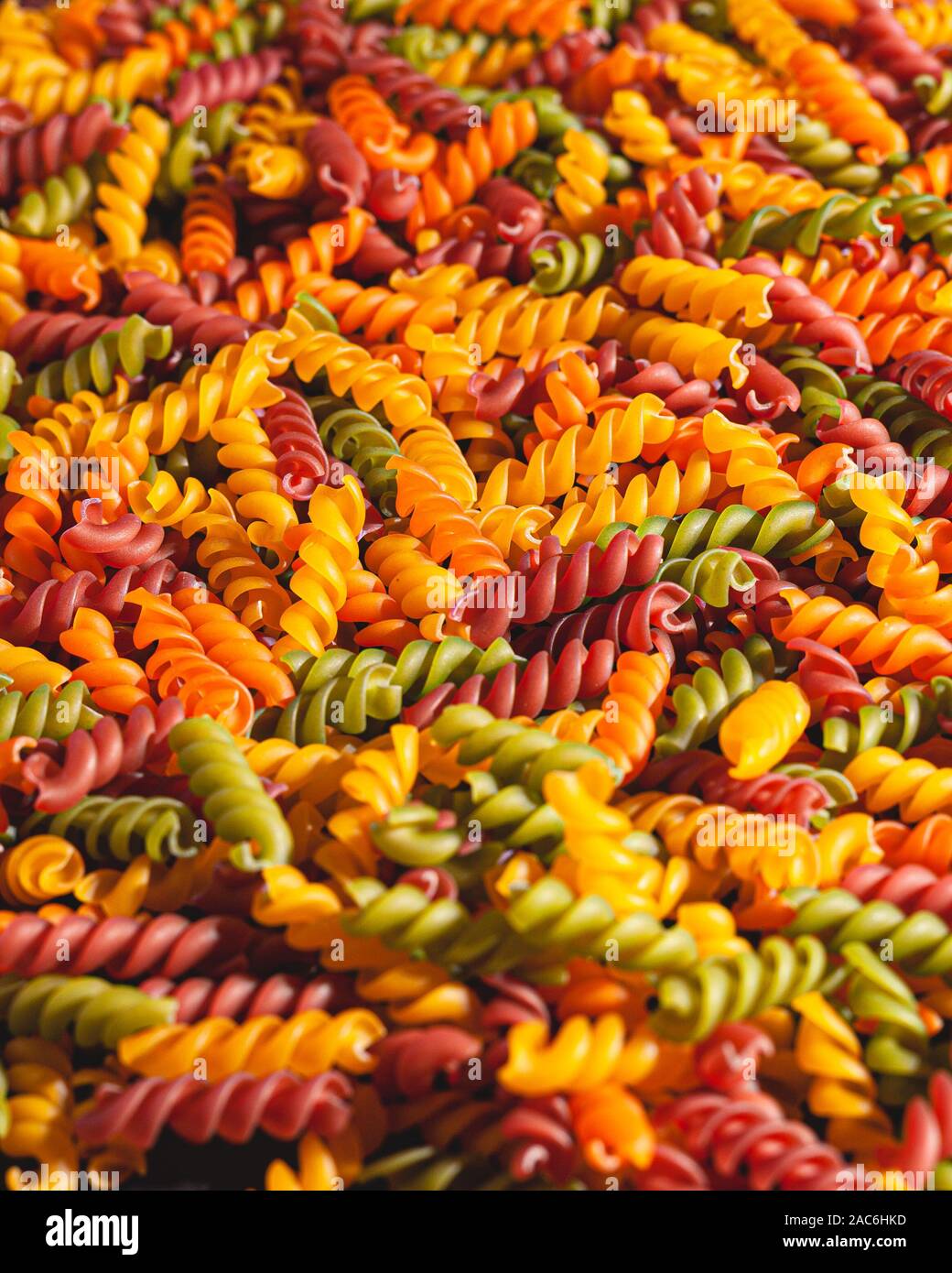 Uncooked tricolore fusilli pasta twist shapes background. Stock photo ...
