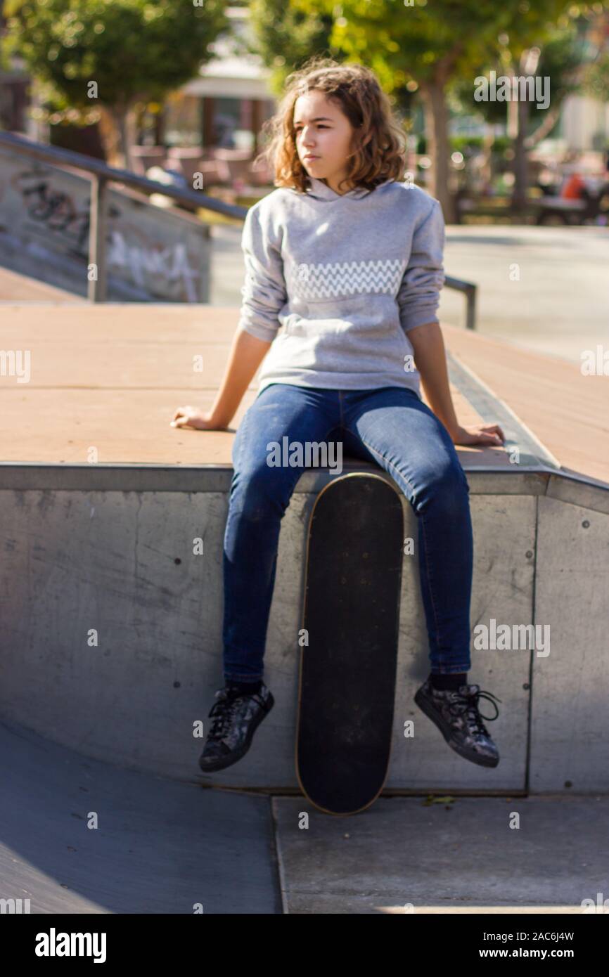Girl teenager sitting with skateboard 