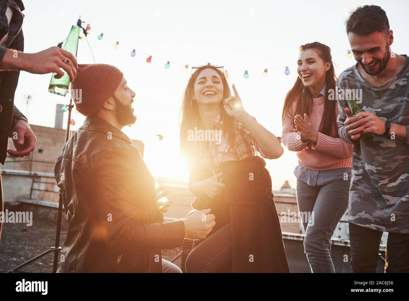 They only friends that joking around. Declaration of love on the rooftop with company of friends Stock Photo