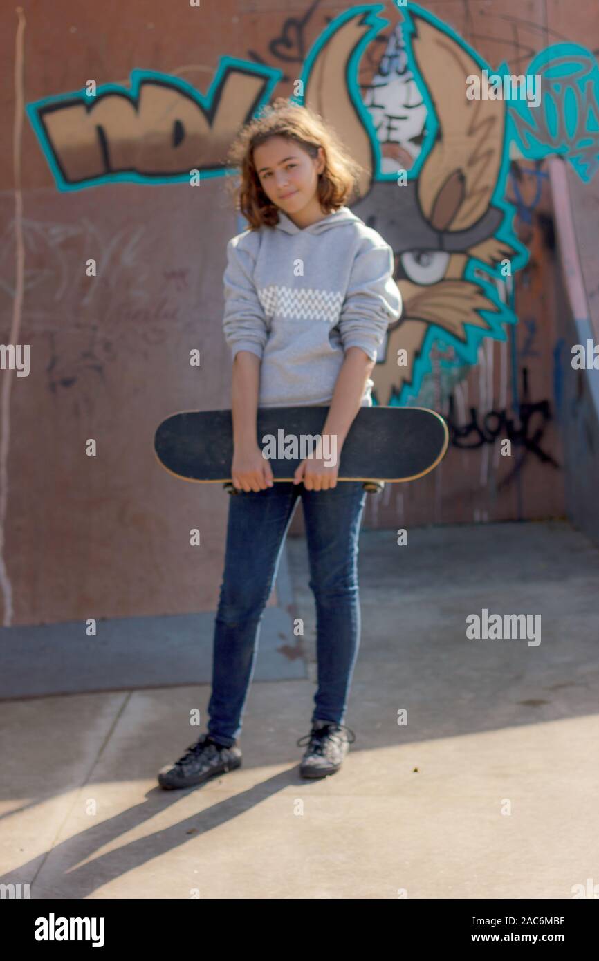 Girl teenager with a skateboard. Beautiful fashionable skateboarder in