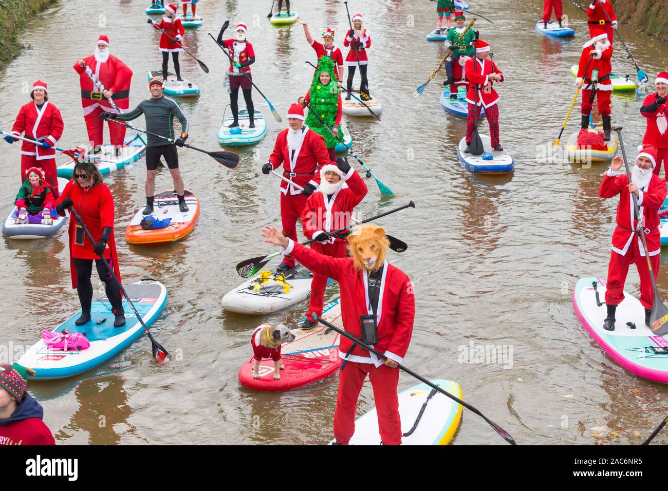 Tonbridge, Kent, UK. 1st Dec, 2019. Now in it's 9th year the stand up for cancer santa paddleboard run is a charitable event started by Jay Manning, a professional paddle boarder, who has held similar events across the country for the past nine years. This time the event is being held on the Medway river in Tonbridge in Kent with a 12 noon start, members of the public are encouraged to watch and donate to this event. ©Paul Lawrenson 2019, Photo Credit: Paul Lawrenson/Alamy Live News Stock Photo