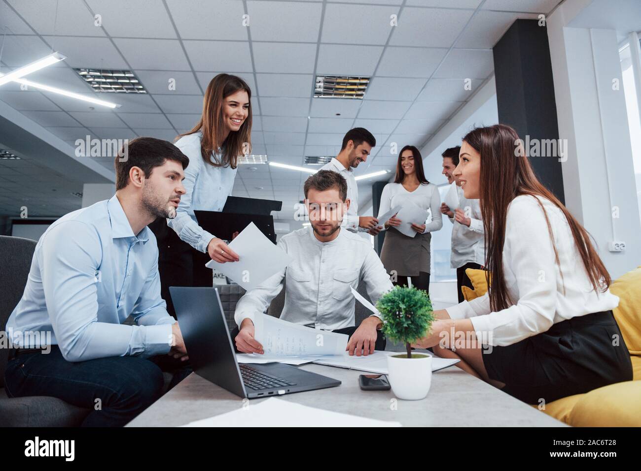 Unity of people for the sake of a great ideas. Group of young freelancers in the office have conversation and smiling Stock Photo