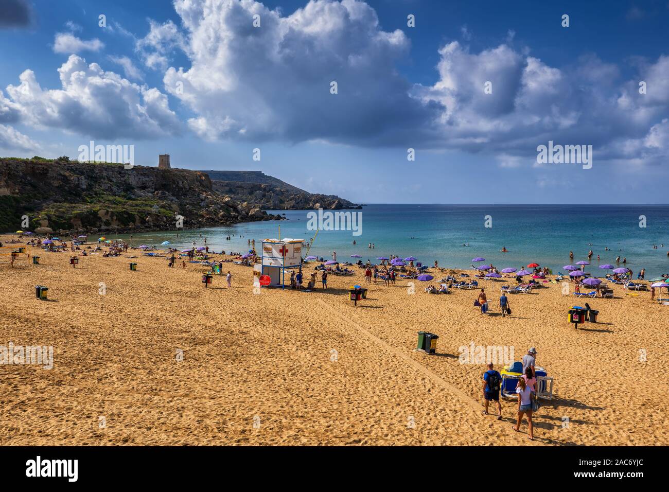 People relax at the Golden Bay sandy beach resort in the north-west coast of Malta island in the Mediterranean Sea Stock Photo