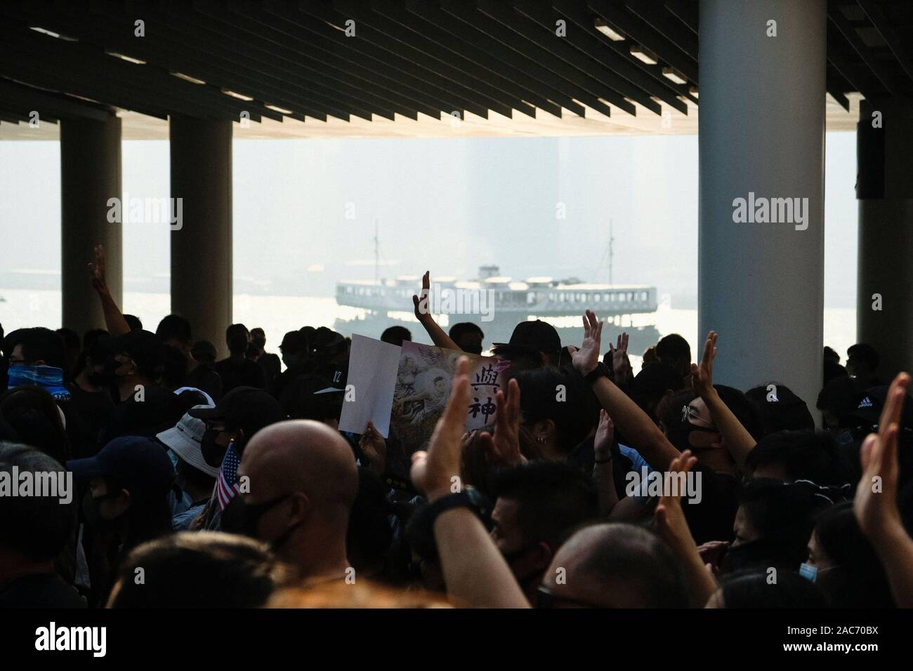 Protesters make gestures during the demonstration.Demonstrations in Hong Kong continue as pro-democracy groups won the District Council elections recently. Protesters continue to call for Hong Kong's government to meet their 5 demands. Stock Photo