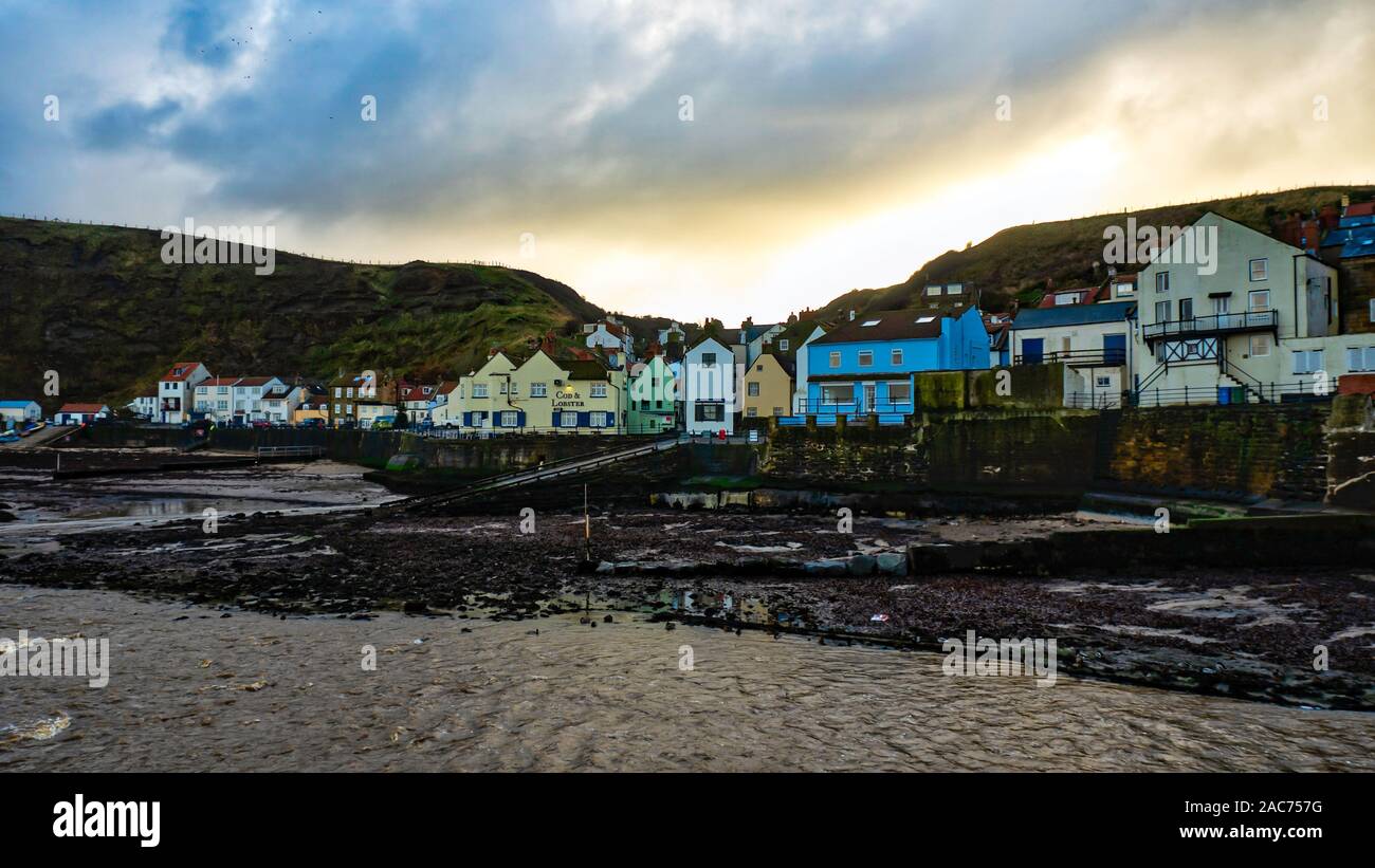 Staithes village seen from across the harbour at sundown in late autumn Stock Photo