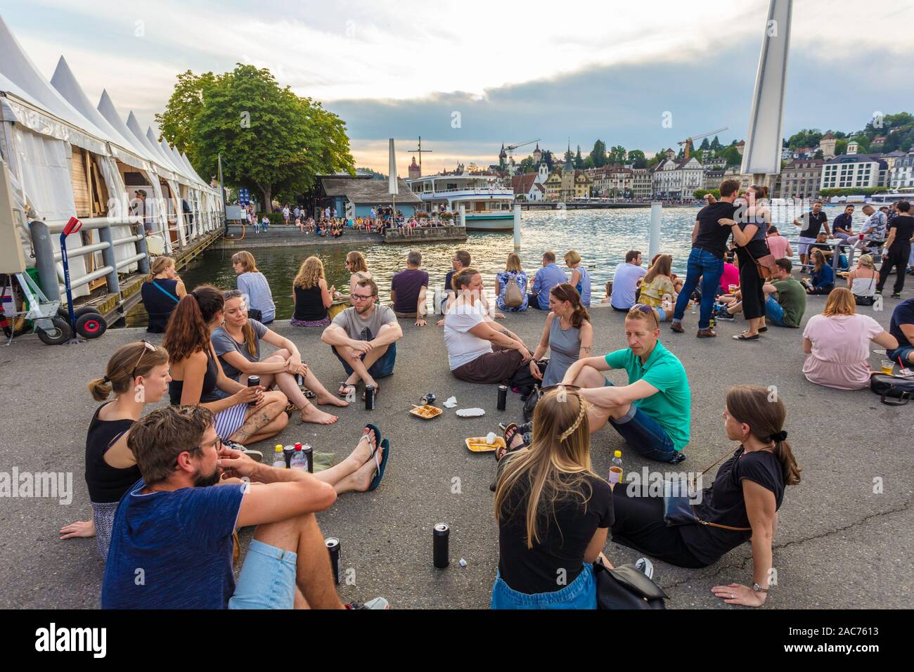 People eating and drinking by the lake during the Blue Balls Festival in Lucerne, Switzerland Stock Photo