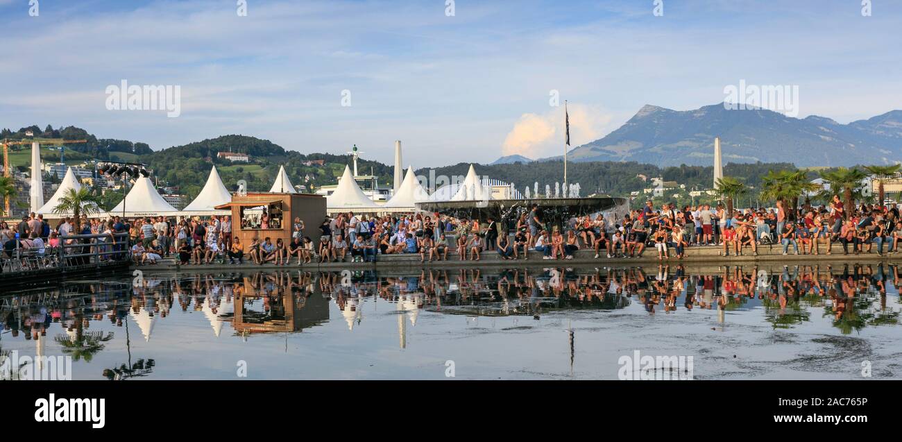 People gather around the Lucerne Concert Hall during the the Blue Balls Festival, Lucerne. Switzerland Stock Photo