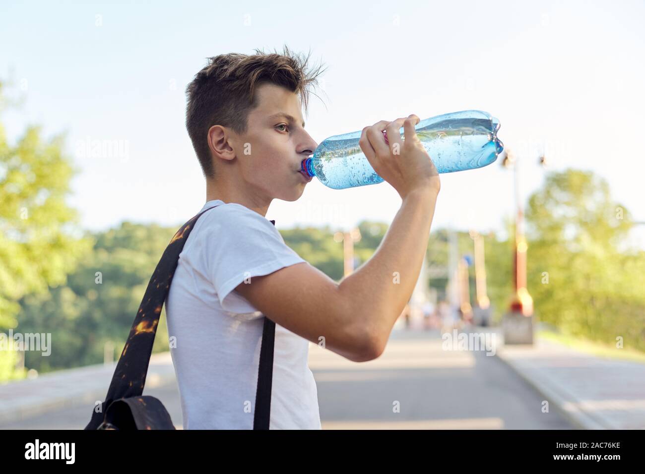 Teenager boy drinking bottle water, hot summer day Stock Photo by  ©Valerii_Honcharuk 321340528