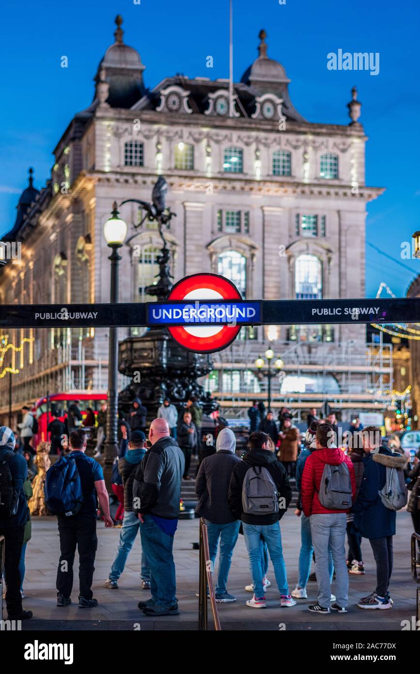 Piccadilly Circus Tourists London - tourists stand outside the Piccadilly Circus Underground Station. Stock Photo