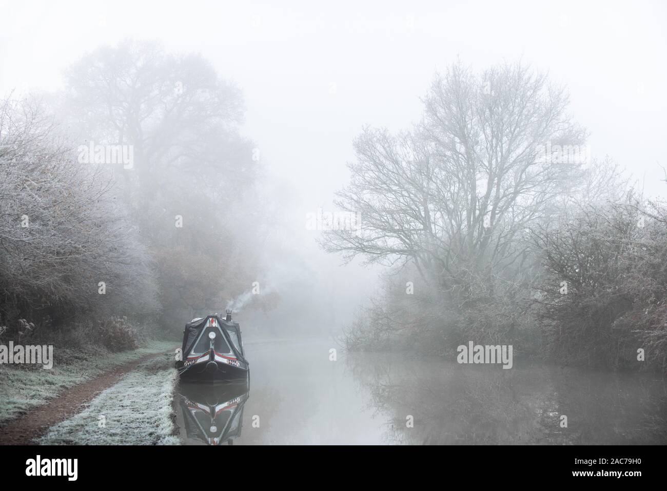 Narrowboat moored on canal in Winter frost Stock Photo