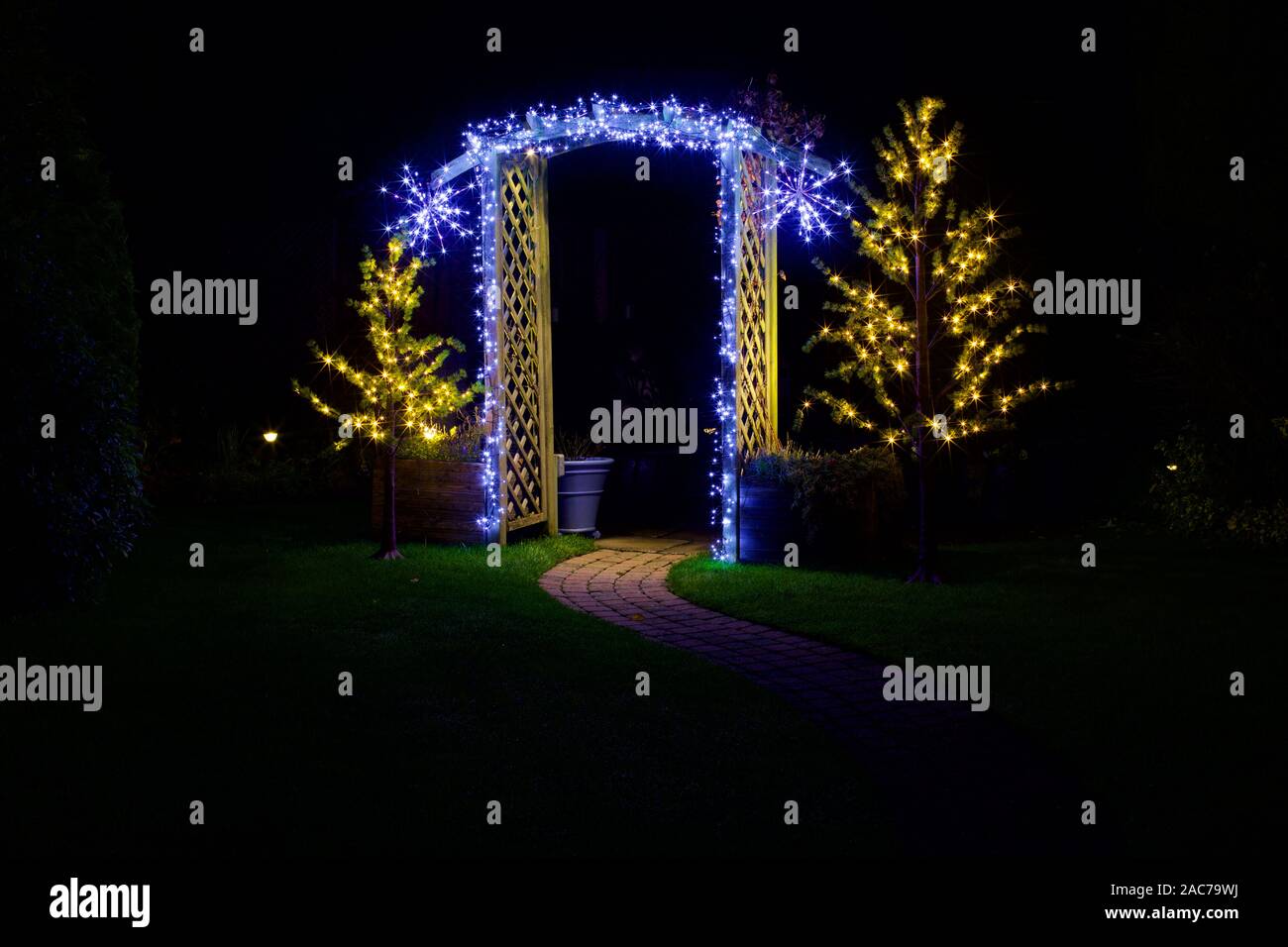 Christmas lights illuminating garden archway Stock Photo Alamy