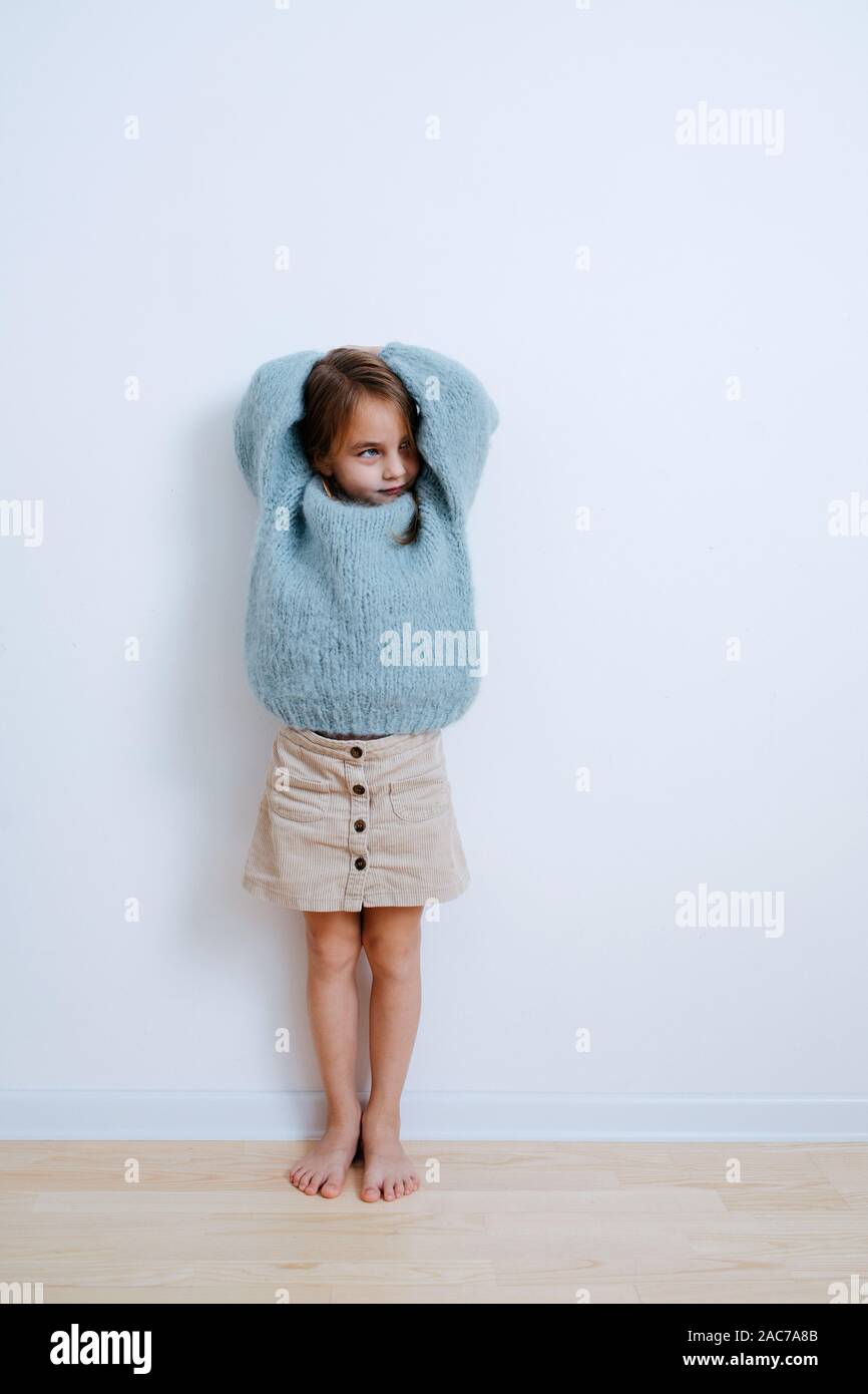 Laughing little barefoot girl in a blue sweater. At home. full length Stock  Photo - Alamy