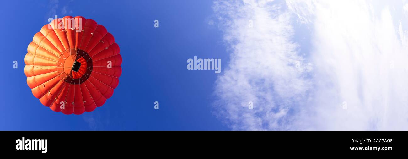 Red hot air balloon in a clear blue sky. Horizontal Stock Photo - Alamy